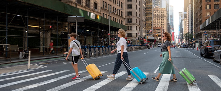 Tourists with luggage walk through NYC