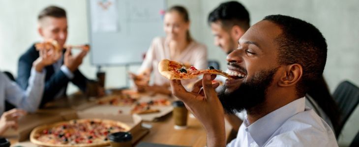 a corporate team eating pizza together