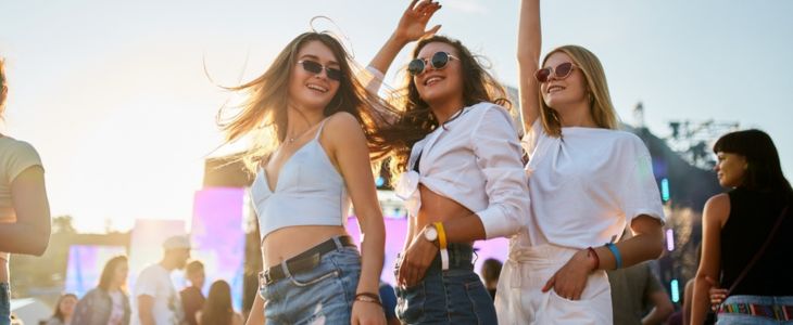 a group of girls smile at a music festival