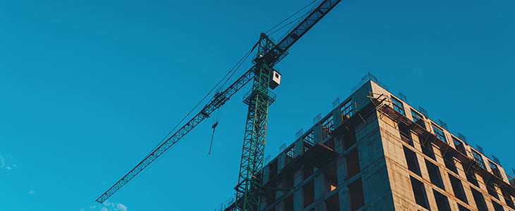 The sun rises over an urban construction site