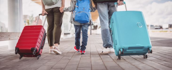 a family walk together rolling suitcases