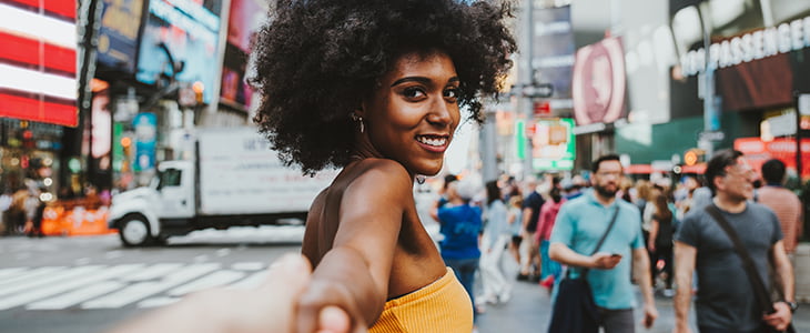 A tourist smiles while walking through Times Square