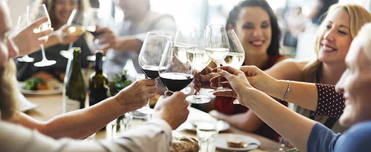 Friends and family toast glasses at a dinner event