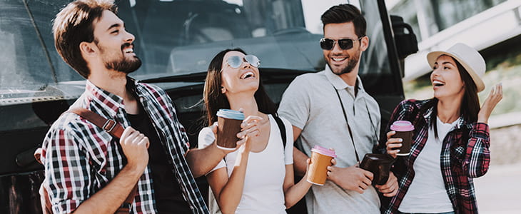 Bus passengers smile outside a charter bus